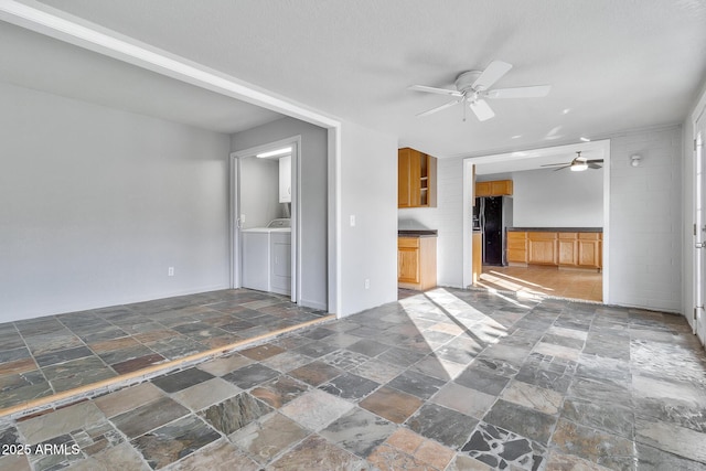 unfurnished living room featuring washer / clothes dryer and ceiling fan