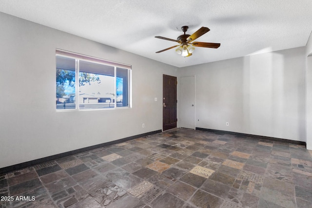 unfurnished room featuring ceiling fan and a textured ceiling