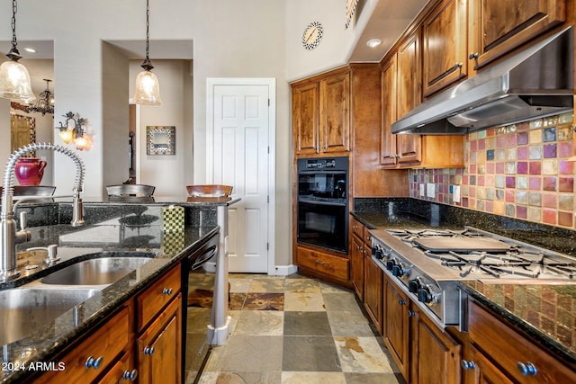 kitchen with black appliances, hanging light fixtures, dark stone counters, and tasteful backsplash