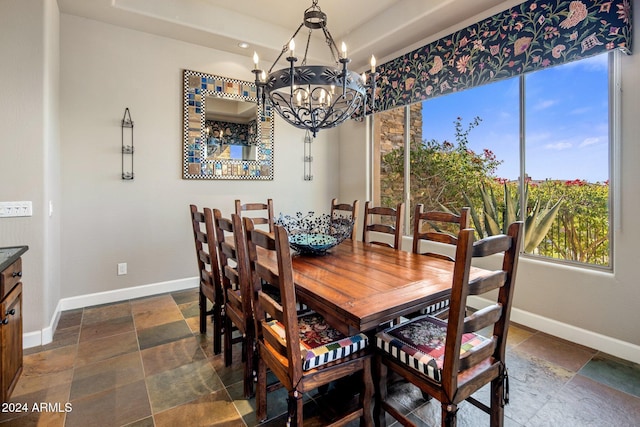 dining space featuring a raised ceiling and a notable chandelier