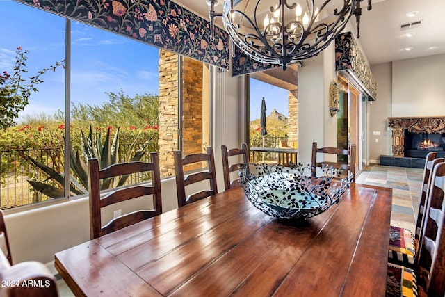 dining room featuring a notable chandelier and a tiled fireplace