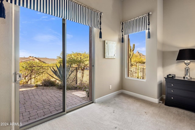 doorway to outside featuring light carpet