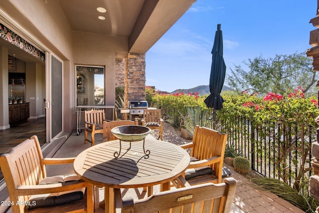 balcony with a mountain view, area for grilling, and a patio area