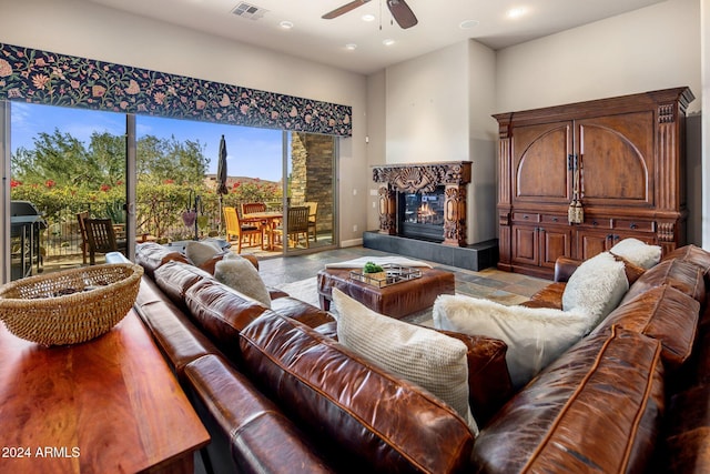 living room featuring a tile fireplace and ceiling fan