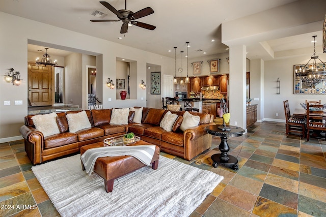 living room featuring ceiling fan with notable chandelier