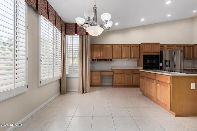 kitchen with hanging light fixtures, a chandelier, vaulted ceiling, light tile patterned floors, and black appliances