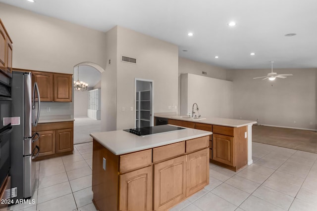 kitchen featuring stainless steel fridge, ceiling fan with notable chandelier, a center island, and black electric cooktop