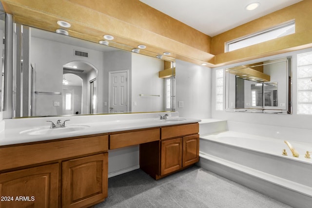 bathroom with vanity and a bath