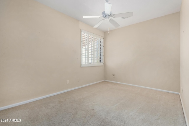 carpeted spare room featuring ceiling fan