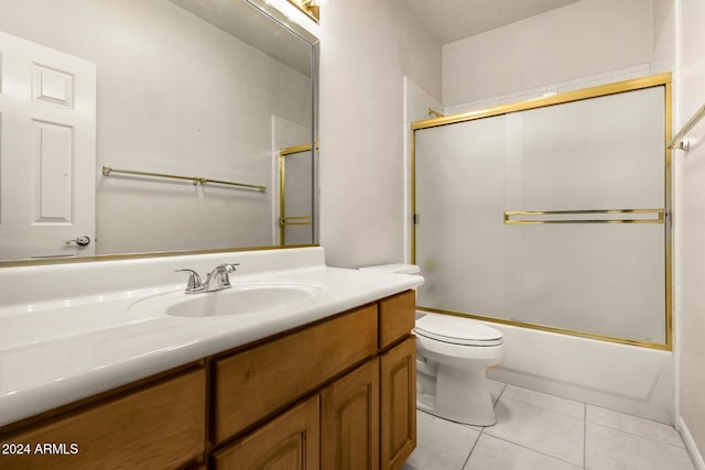 full bathroom featuring tile patterned flooring, vanity, toilet, and bath / shower combo with glass door