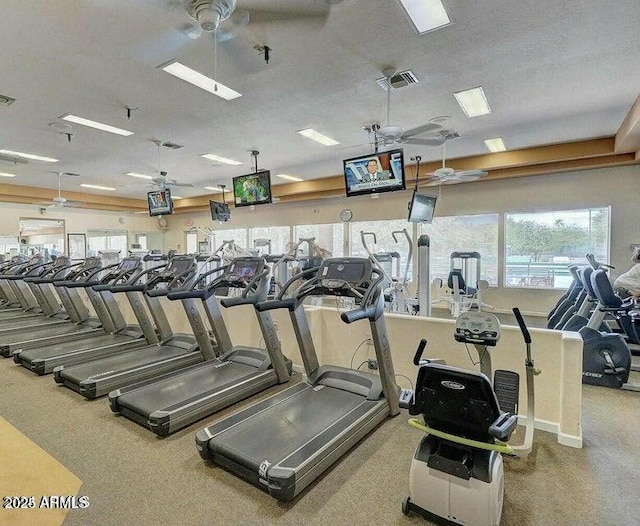 gym featuring ceiling fan and a textured ceiling