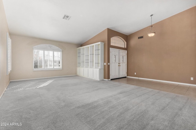 carpeted empty room with vaulted ceiling