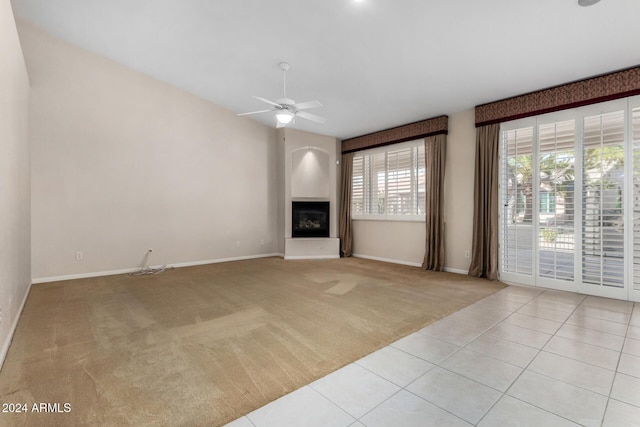 unfurnished living room with ceiling fan and light tile patterned floors