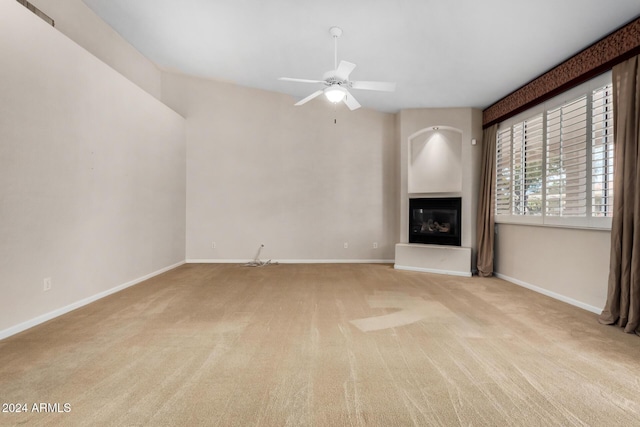 unfurnished living room with light colored carpet and ceiling fan