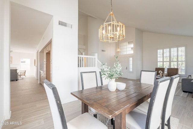 3837 E Windsong Dr, Phoenix, AZ 85048 - dining area featuring a chandelier, baseboards, high vaulted ceiling, and light wood-style floors