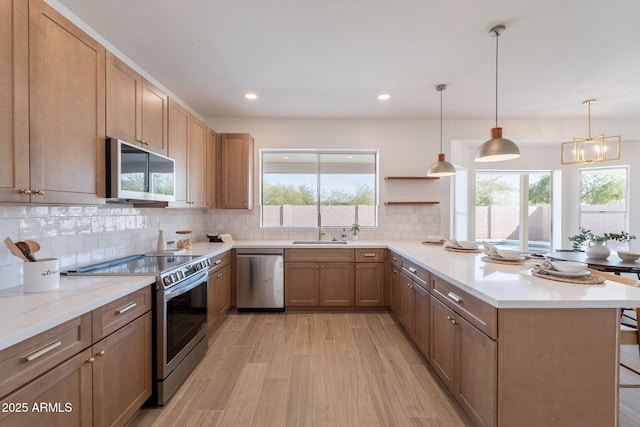 3837 E Windsong Dr, Phoenix, AZ 85048 - kitchen with appliances with stainless steel finishes, a peninsula, backsplash, healthy amount of natural light, and recessed lighting