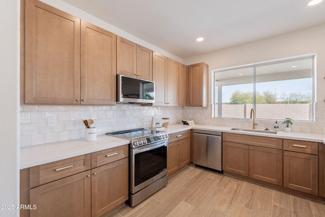3837 E Windsong Dr, Phoenix, AZ 85048 - kitchen featuring stainless steel appliances, a sink, backsplash, light wood-style floors, and recessed lighting