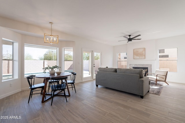 3837 E Windsong Dr, Phoenix, AZ 85048 - dining space with a chandelier, light wood-style flooring, a tile fireplace, and baseboards