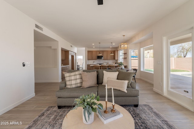 3837 E Windsong Dr, Phoenix, AZ 85048 - living area featuring light wood-style floors, a chandelier, baseboards, and recessed lighting