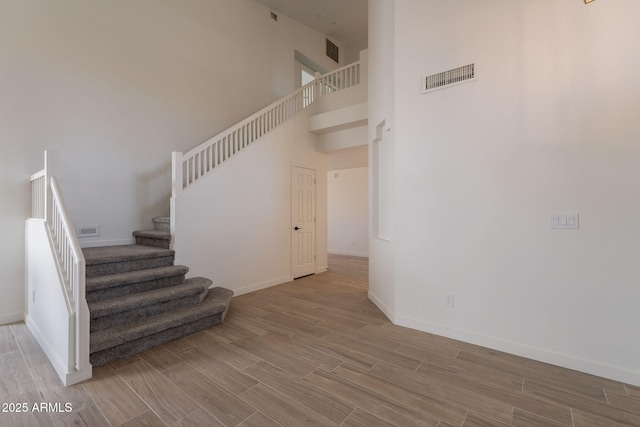 3837 E Windsong Dr, Phoenix, AZ 85048 - staircase featuring wood finished floors, baseboards, and a towering ceiling