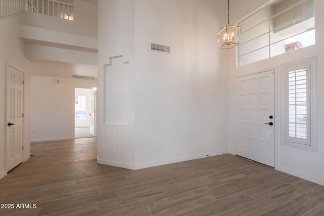 3837 E Windsong Dr, Phoenix, AZ 85048 - foyer with a high ceiling, a chandelier, wood finished floors, and baseboards