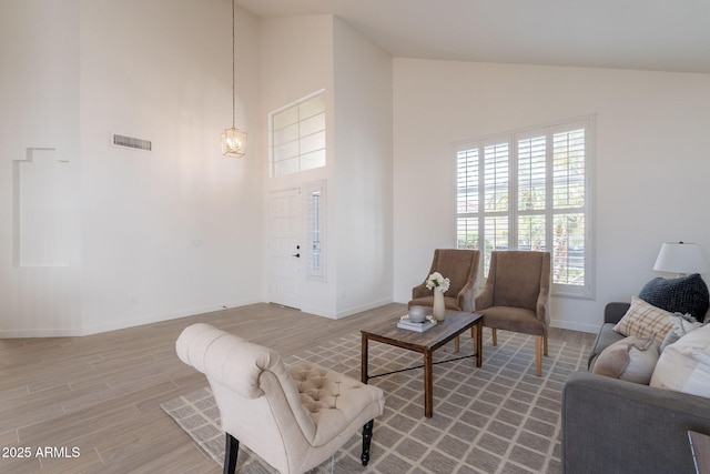 3837 E Windsong Dr, Phoenix, AZ 85048 - living area featuring high vaulted ceiling, light wood-type flooring, baseboards, and a chandelier