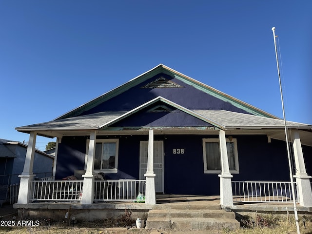 view of front of home featuring covered porch and a shingled roof