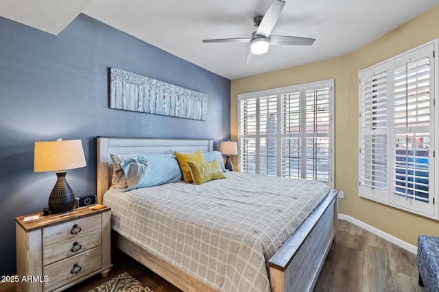 bedroom featuring baseboards, dark wood finished floors, and ceiling fan