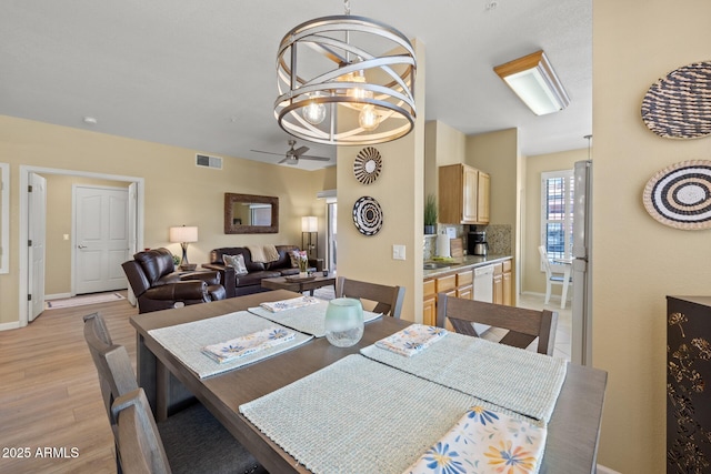 dining area featuring visible vents, baseboards, ceiling fan, and light wood-type flooring