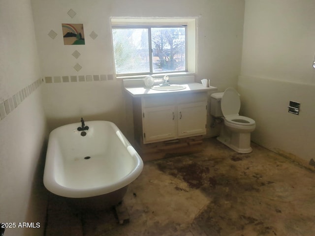 bathroom featuring a freestanding bath, vanity, and toilet