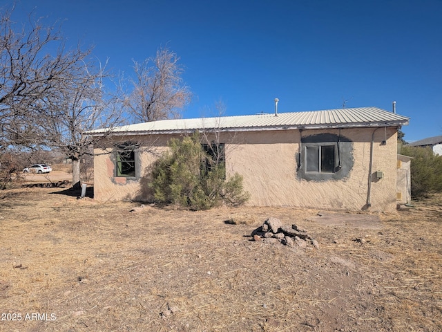 view of property exterior with metal roof and stucco siding