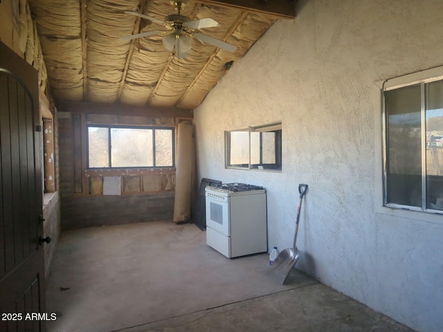 interior space featuring vaulted ceiling, unfinished concrete flooring, and ceiling fan