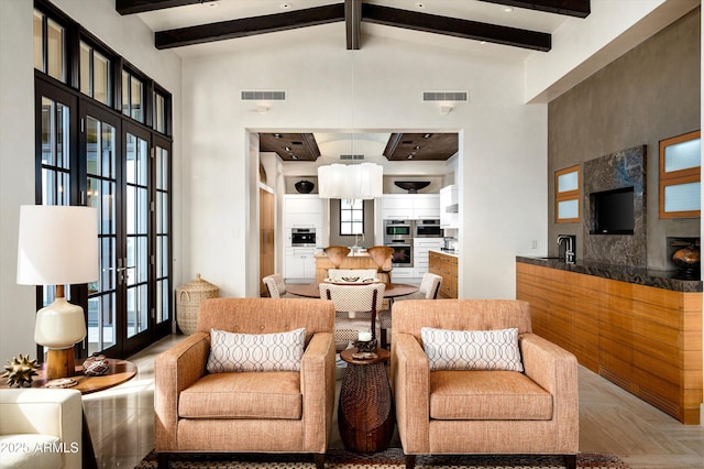 living area featuring a wealth of natural light, beamed ceiling, and visible vents