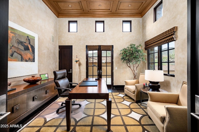 office space featuring crown molding, plenty of natural light, french doors, and a towering ceiling