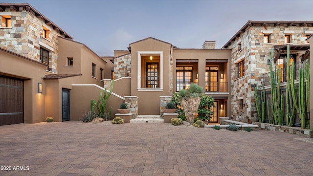 view of front of home with a chimney and stucco siding