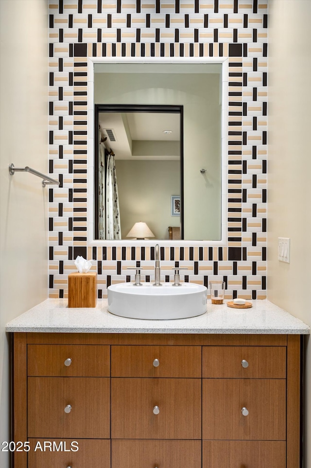 bathroom with vanity, tasteful backsplash, and visible vents