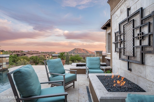 view of patio / terrace with a mountain view and a fire pit