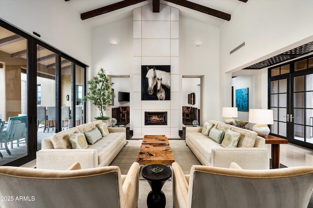 living room featuring high vaulted ceiling, wood finished floors, beam ceiling, and a tile fireplace