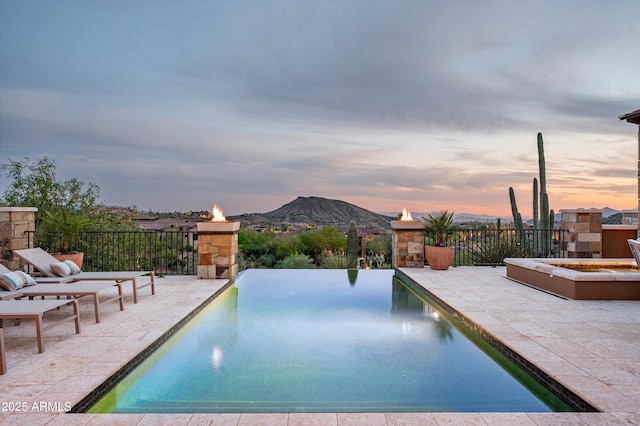 view of pool featuring a fenced in pool, a mountain view, and a patio area