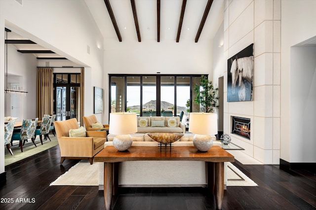 living area featuring dark wood-style flooring, a high ceiling, a fireplace, recessed lighting, and beamed ceiling