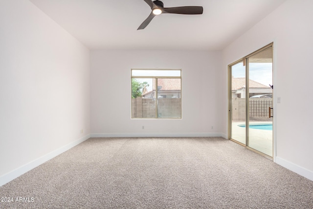 carpeted spare room with a healthy amount of sunlight and ceiling fan