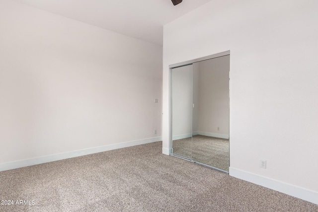 unfurnished bedroom with ceiling fan, a closet, and carpet floors