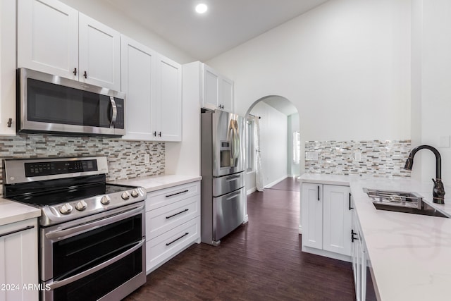 kitchen with appliances with stainless steel finishes, dark hardwood / wood-style floors, sink, and white cabinets