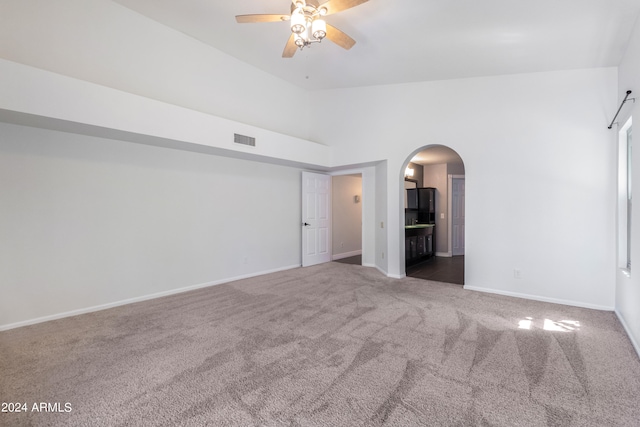 unfurnished room featuring high vaulted ceiling, ceiling fan, and carpet floors