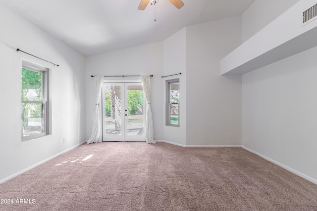 carpeted spare room with high vaulted ceiling, ceiling fan, and a wealth of natural light