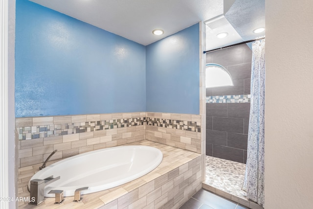 bathroom with independent shower and bath and tile patterned flooring