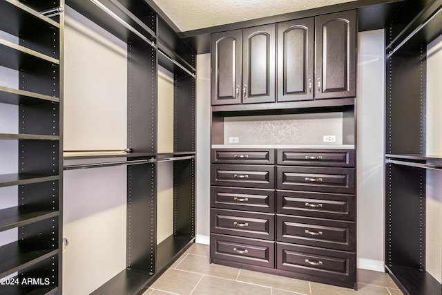 walk in closet with light tile patterned flooring