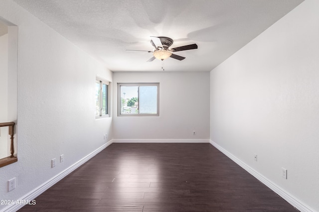 empty room featuring a textured ceiling, dark hardwood / wood-style flooring, and ceiling fan