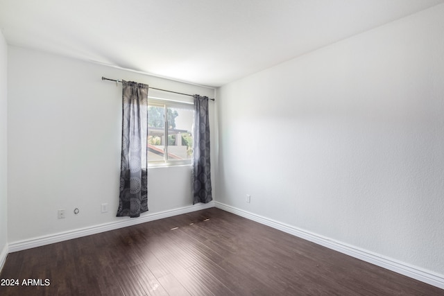 empty room with dark hardwood / wood-style flooring