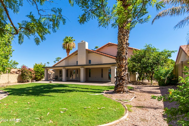 rear view of house featuring a yard